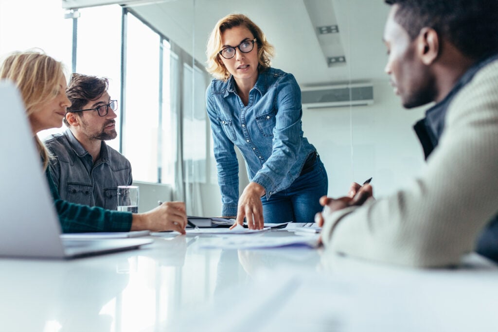 Mulher fala com assertividade no trabalho em reunião de equipe